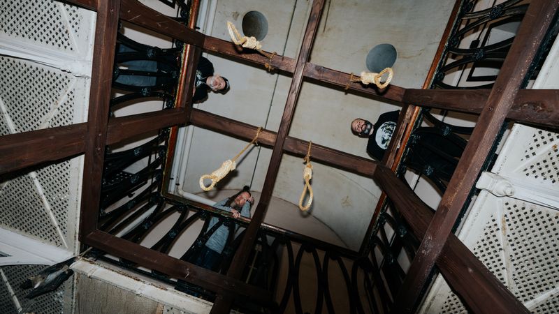 Barry, John and Ty looking down through a haunted stairwell lined with hanging nooses